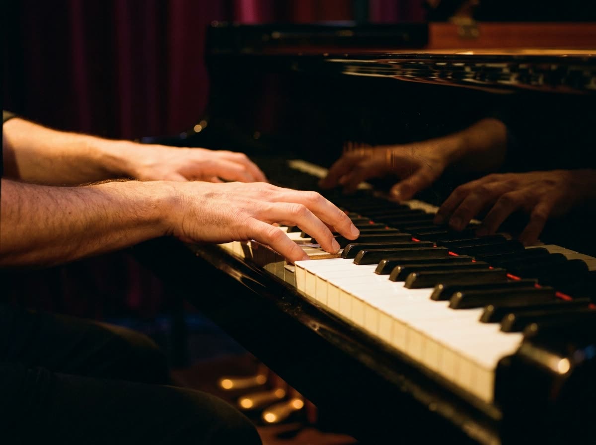 Close view of two hands playing a chord on piano keys.